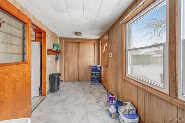 hallway featuring wood walls