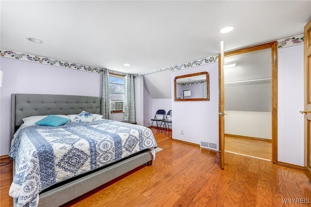 bedroom with lofted ceiling and hardwood / wood-style floors