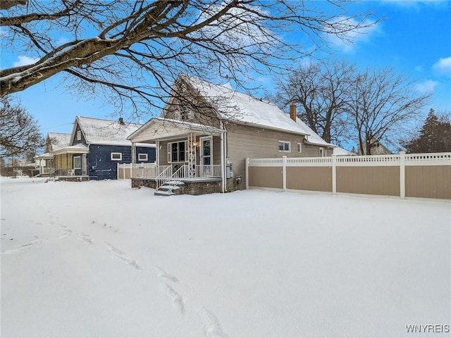 view of snow covered back of property