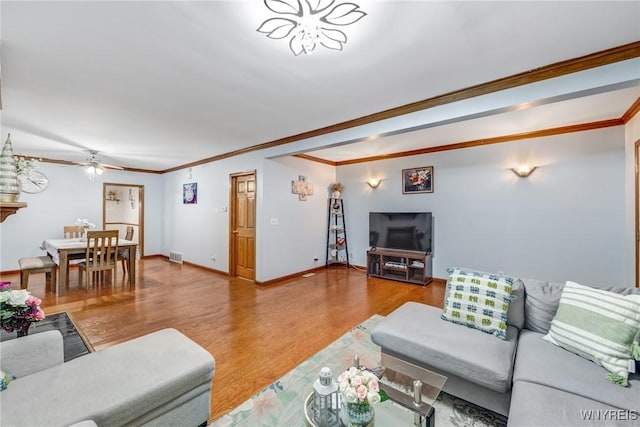 living room featuring ceiling fan, ornamental molding, and hardwood / wood-style flooring