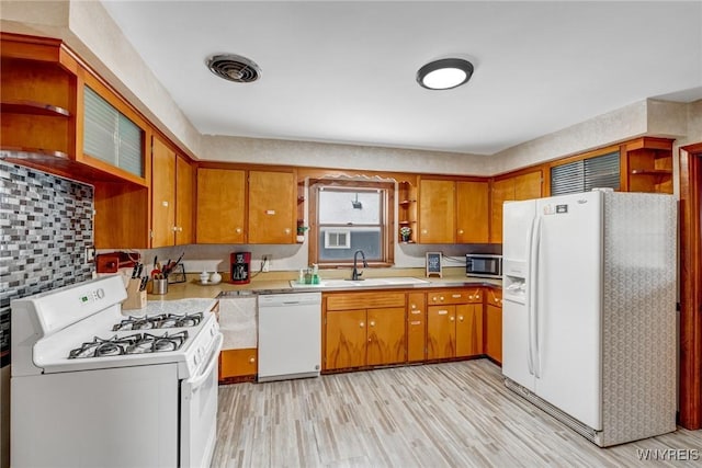 kitchen with sink, white appliances, and light hardwood / wood-style flooring