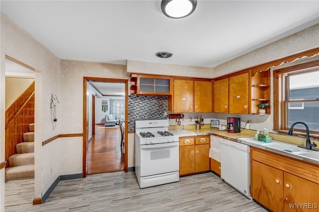 kitchen with sink, white appliances, and light wood-type flooring