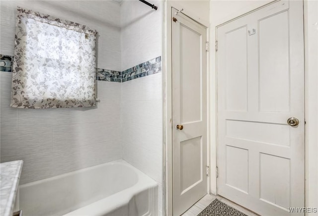 bathroom featuring tiled shower / bath combo and vanity