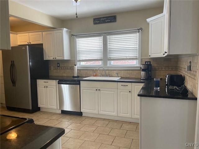 kitchen featuring stainless steel appliances, decorative backsplash, white cabinetry, and sink