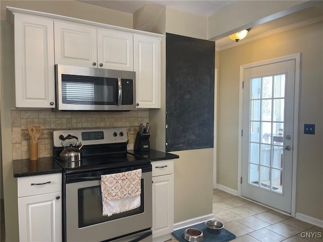 kitchen featuring backsplash, white cabinetry, light tile patterned floors, and stainless steel appliances