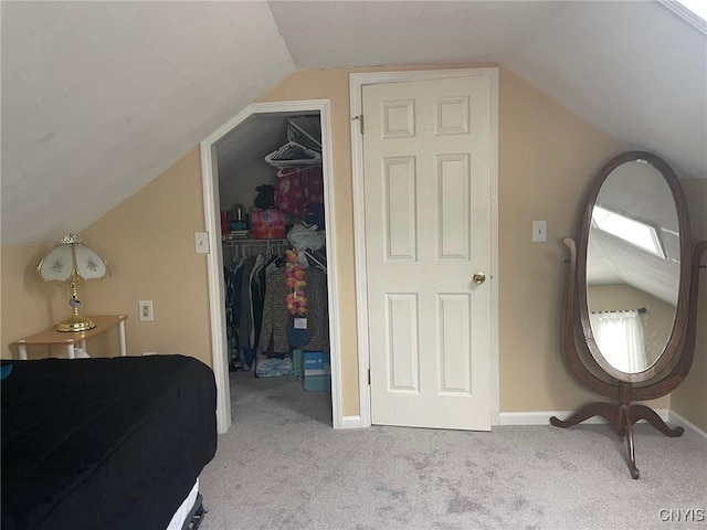 bedroom with a closet, light carpet, and vaulted ceiling