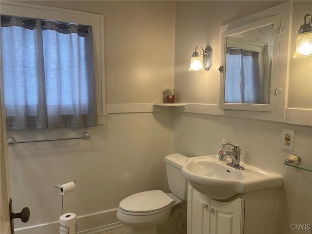 bathroom with toilet, vanity, and backsplash