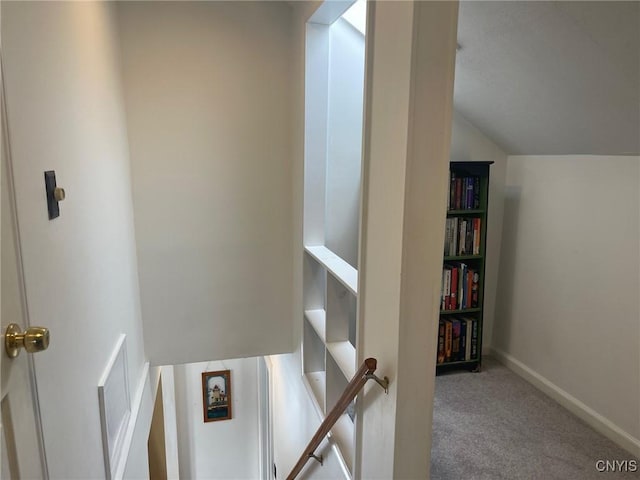 hallway with carpet flooring and lofted ceiling