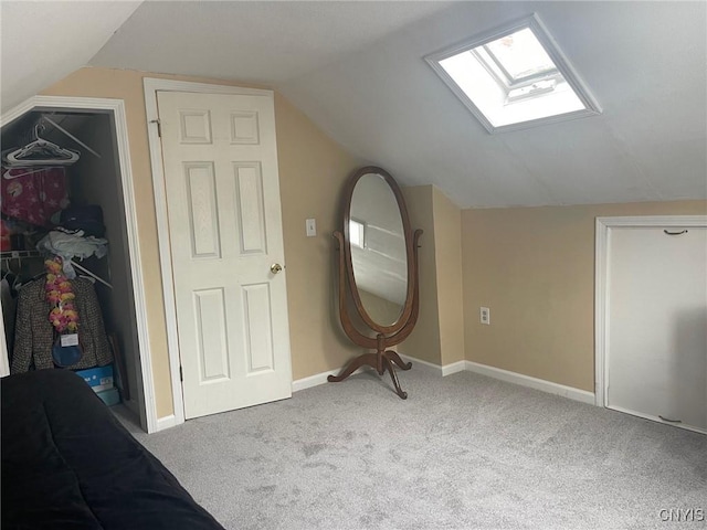 bonus room featuring vaulted ceiling with skylight and light colored carpet