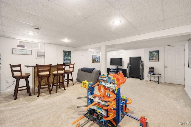 recreation room featuring carpet, a paneled ceiling, and bar