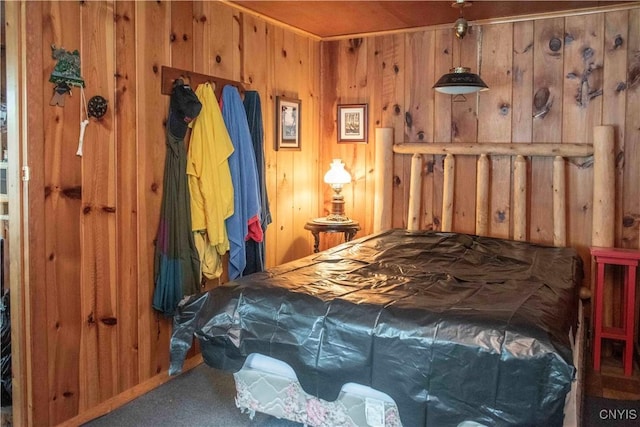 carpeted bedroom featuring wood walls