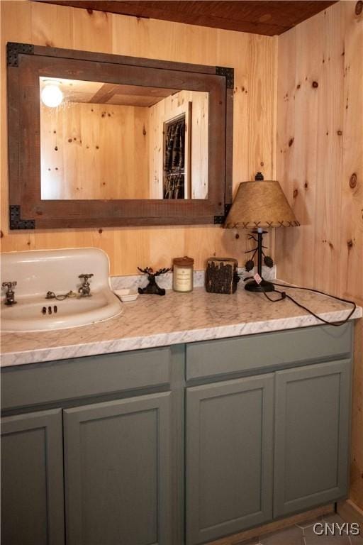 bathroom with wood ceiling, tile patterned floors, wood walls, and vanity