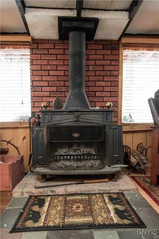 room details featuring wooden walls and a wood stove