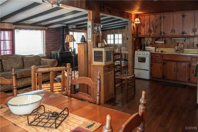 dining space featuring dark wood-type flooring, a wood stove, lofted ceiling with beams, and wooden walls