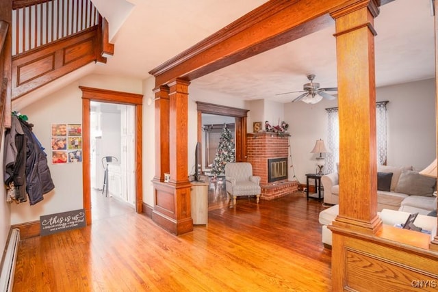 corridor with decorative columns, light hardwood / wood-style floors, and a baseboard heating unit