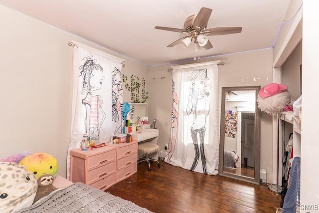 bedroom with ceiling fan, dark wood-type flooring, and multiple windows