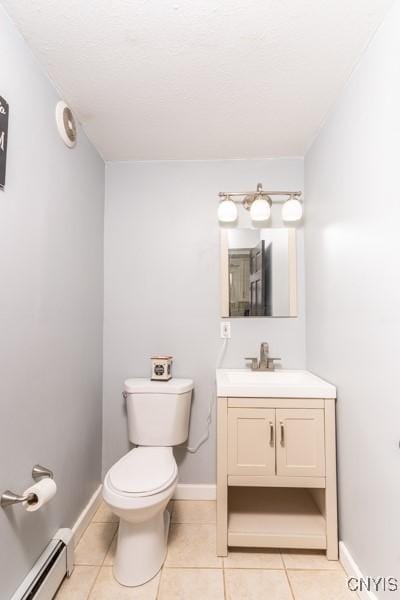 bathroom with tile patterned flooring, vanity, baseboard heating, and toilet