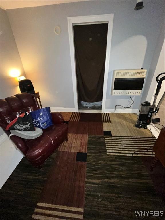 living room featuring heating unit and dark wood-type flooring