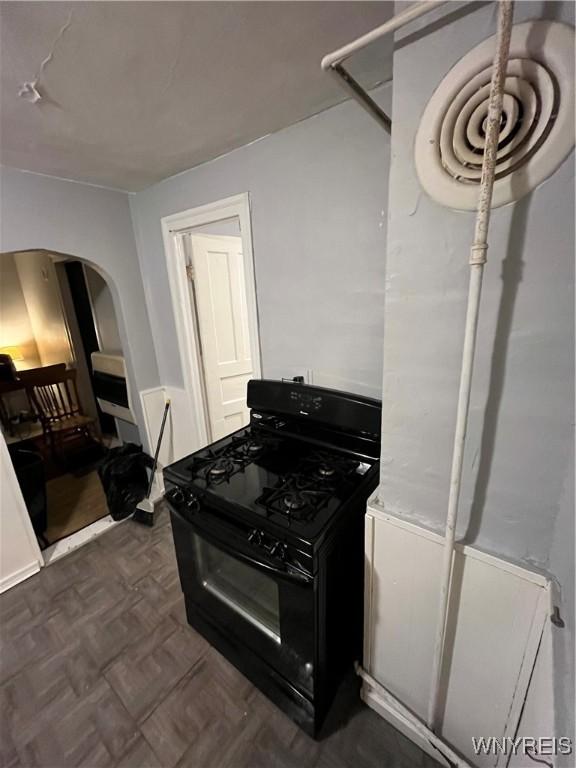 kitchen featuring black gas range and dark parquet floors