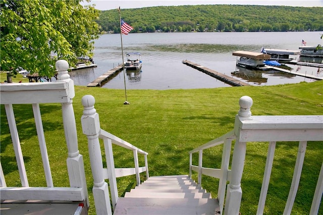 dock area featuring a lawn and a water view