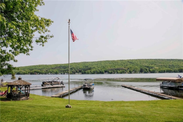 dock area featuring a gazebo, a yard, and a water view