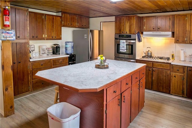 kitchen with wooden ceiling, appliances with stainless steel finishes, light hardwood / wood-style flooring, and a center island