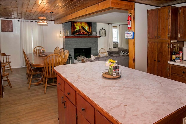 kitchen featuring light hardwood / wood-style flooring, tile counters, and a fireplace