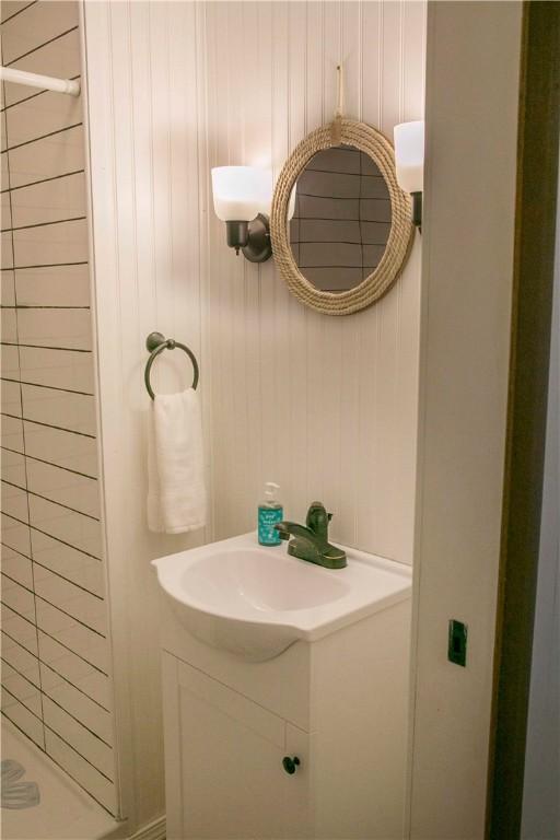 bathroom featuring vanity and wood walls