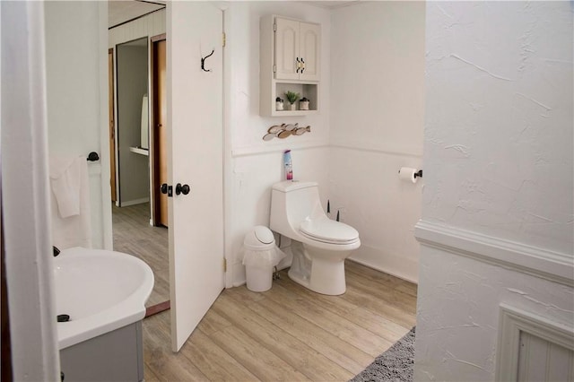 bathroom featuring toilet, vanity, and hardwood / wood-style flooring