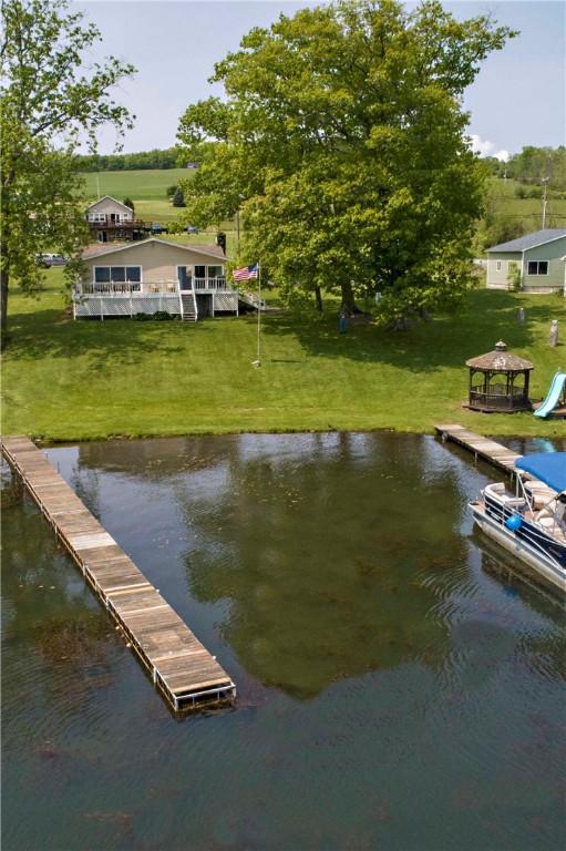 dock area featuring a water view, a gazebo, and a yard