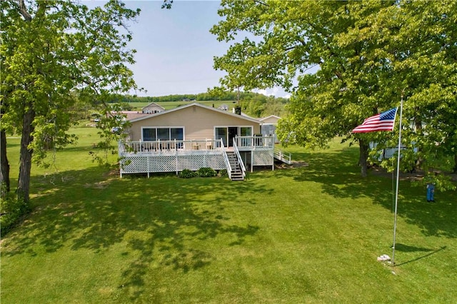 rear view of property featuring a lawn and a wooden deck