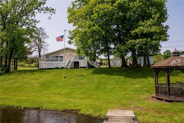 view of yard with a gazebo and a deck with water view