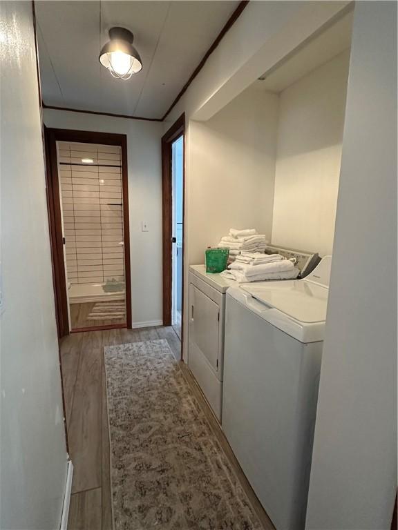 laundry area with light hardwood / wood-style floors and separate washer and dryer