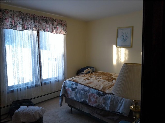 carpeted bedroom featuring multiple windows and a baseboard radiator