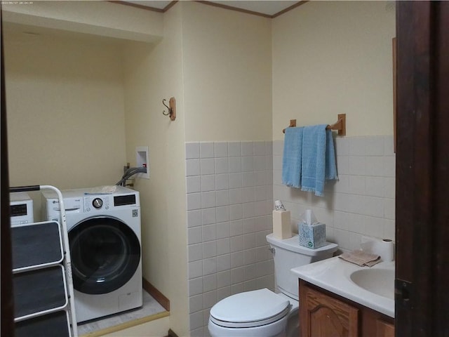 bathroom with vanity, washer / dryer, tile walls, and toilet