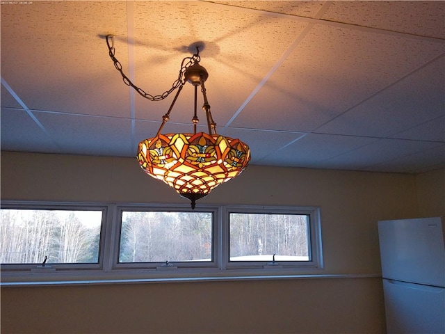 details featuring a drop ceiling and white refrigerator