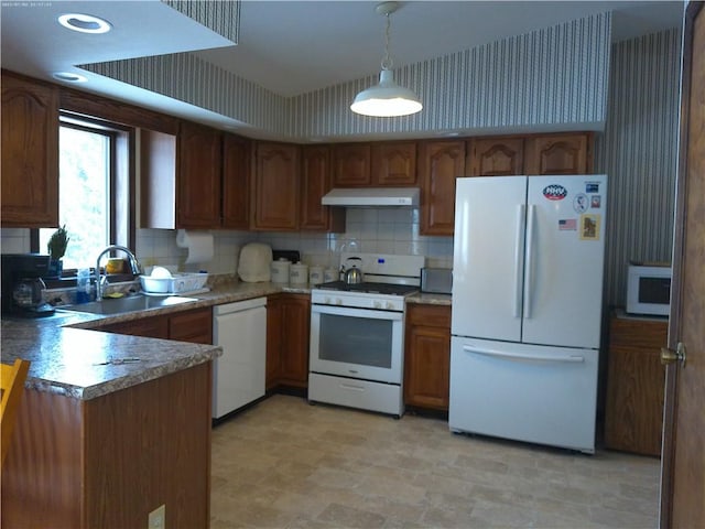 kitchen with tasteful backsplash, hanging light fixtures, white appliances, and sink