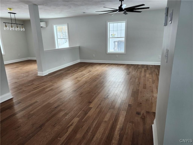 empty room featuring ceiling fan, dark wood-type flooring, and an AC wall unit