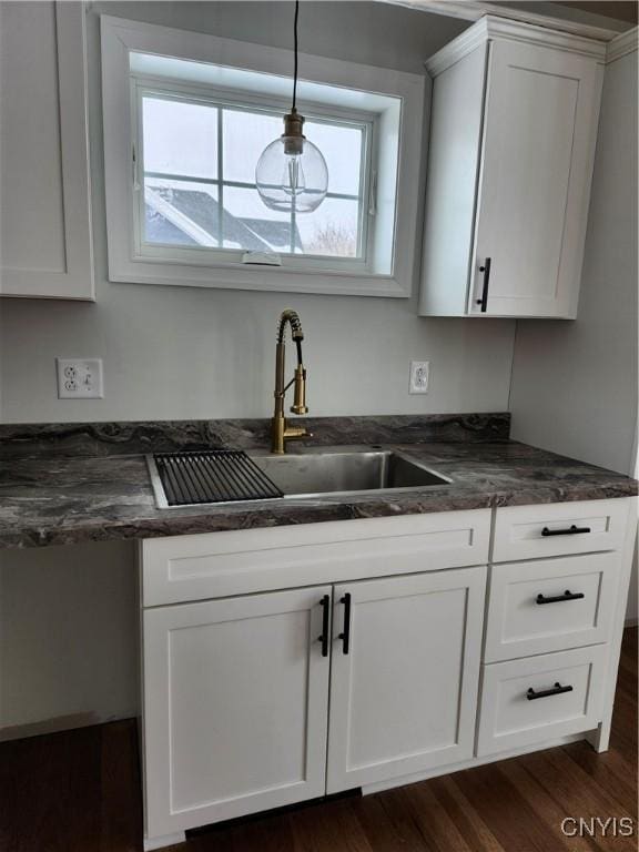 kitchen with white cabinets, hanging light fixtures, and sink