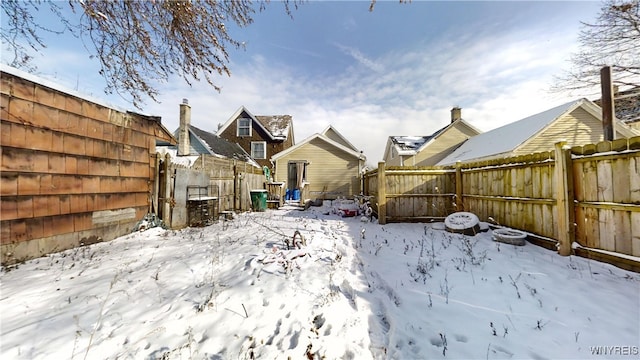 yard layered in snow featuring fence and an outdoor structure