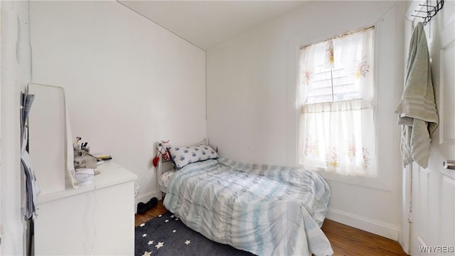 bedroom featuring wood finished floors and baseboards