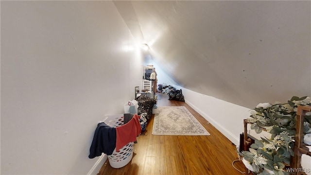 interior space featuring wood-type flooring and vaulted ceiling