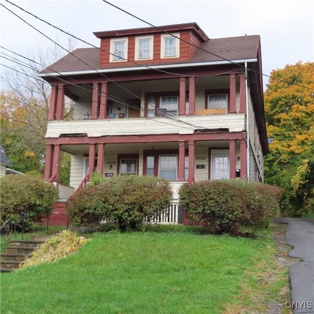 view of front of property with a balcony and a front yard