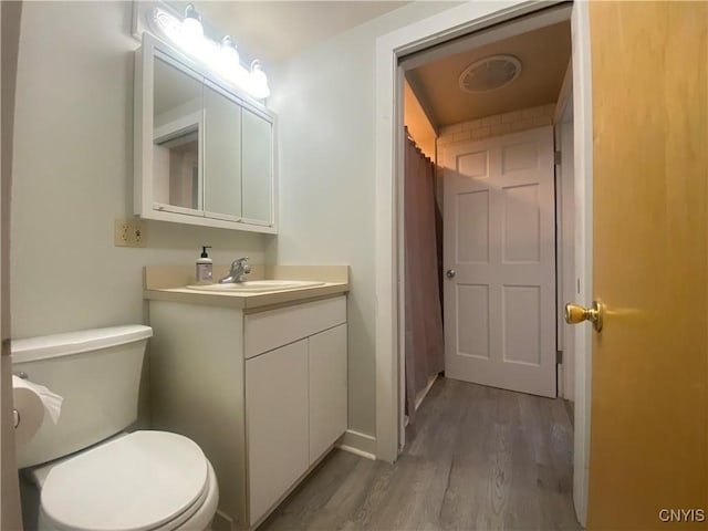 bathroom featuring hardwood / wood-style floors, toilet, and vanity