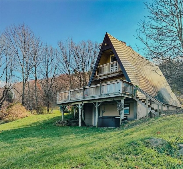 rear view of property featuring a deck and a lawn