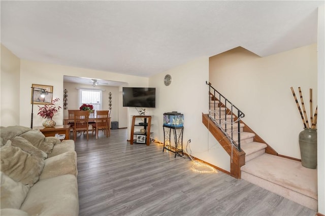 living room featuring ceiling fan and hardwood / wood-style flooring