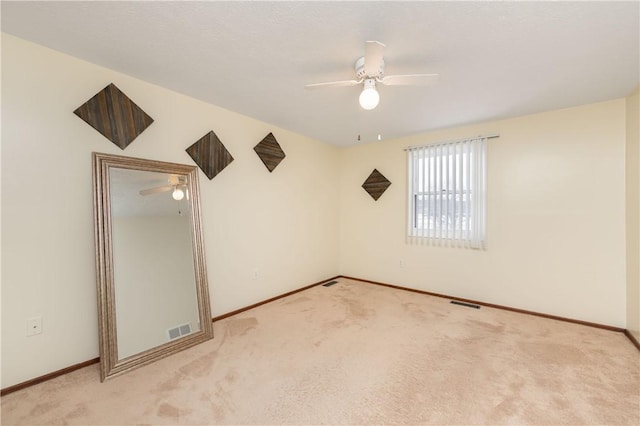 unfurnished room with ceiling fan and light colored carpet