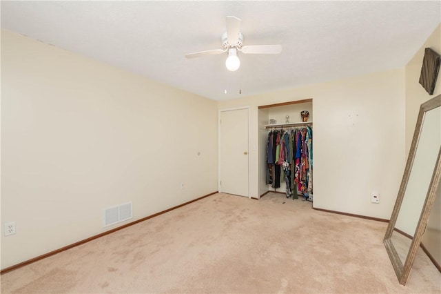 unfurnished bedroom with ceiling fan, a closet, and light carpet