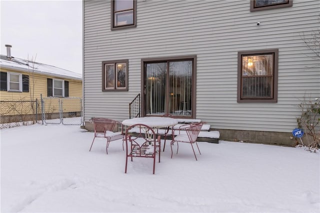 view of snow covered back of property