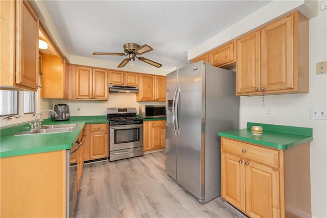 kitchen with ceiling fan, appliances with stainless steel finishes, sink, and light hardwood / wood-style floors